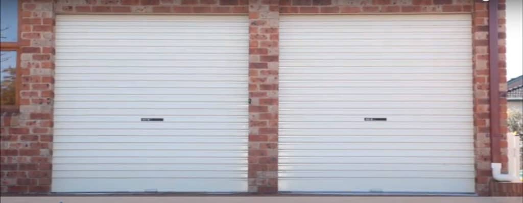 2 Garage Doors on a brick housing